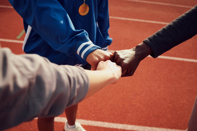 Foto van een 'team' met de vuisten tegen elkaar aan